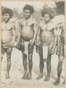 Men standing in a row outside, houses in the background