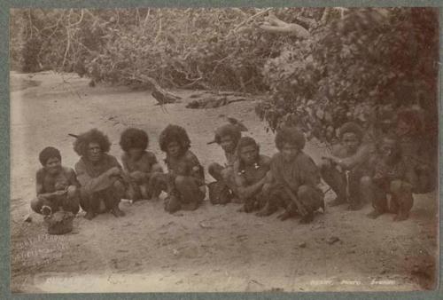 Group of people sitting in a row on the ground