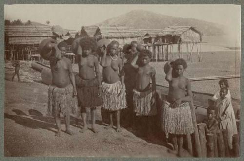 People holding jugs, buildings in background