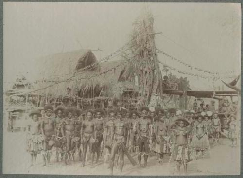 Group, men with drums, strings of yams hung from tower