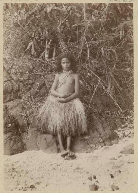 Girl standing outside in grass skirt