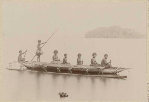 People in outrigger canoe on the water