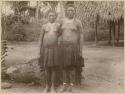 Two women in front of tree stump