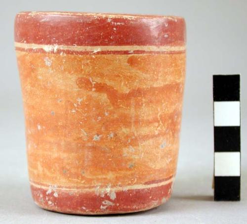 Small ceramic cup, plain, orange and red.