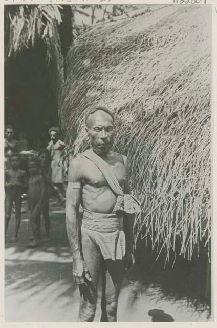 Man standing in front of a hut