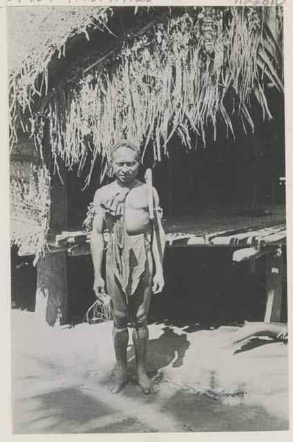 Man standing in front of a hut