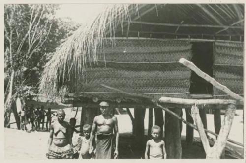 Government representative, with his wife and children in front of house