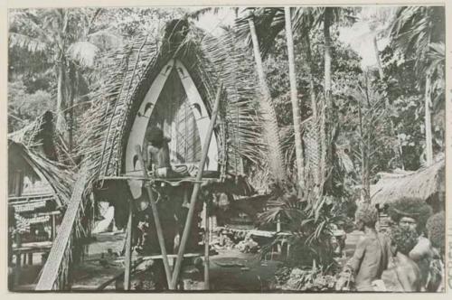 Person sitting in front of house with painted decoration