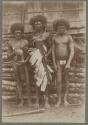 Three men standing in front of a building