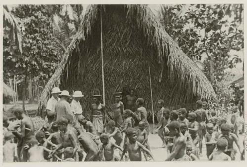 Group in front of thatched structure