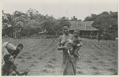 Woman holding child and small monkey