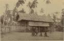 Women and children in front of house on stilts