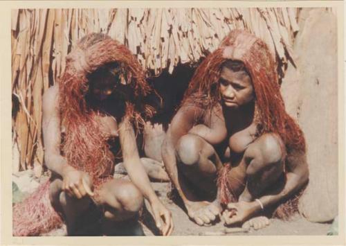 Two women in front of hut