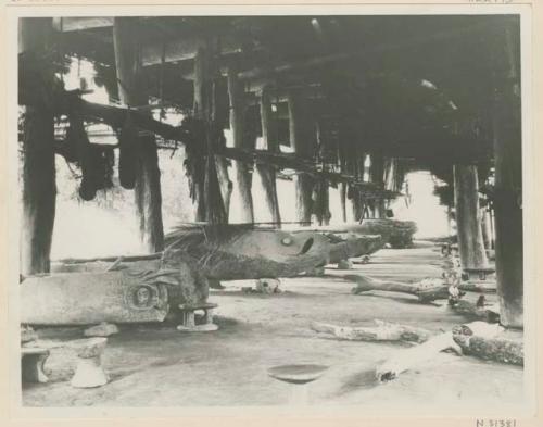 View under house; drums and charred logs