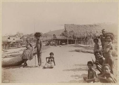 People and thatched buildings on stilts