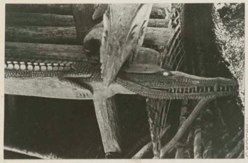 Detail of carved crocodile on beam supporting a house