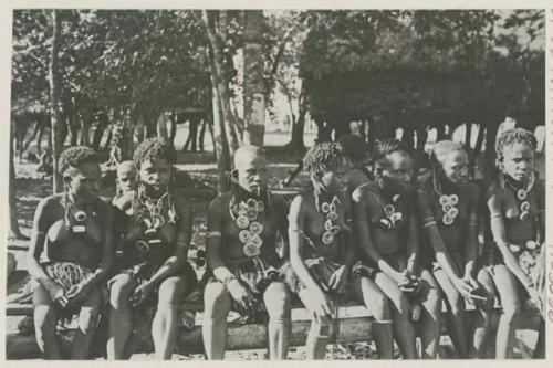 Women seated on fence