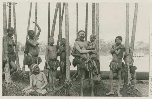 Women and children standing among trees