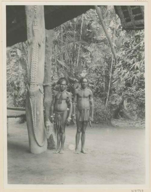 Two men beside carved crocodile column in haus Tambaran