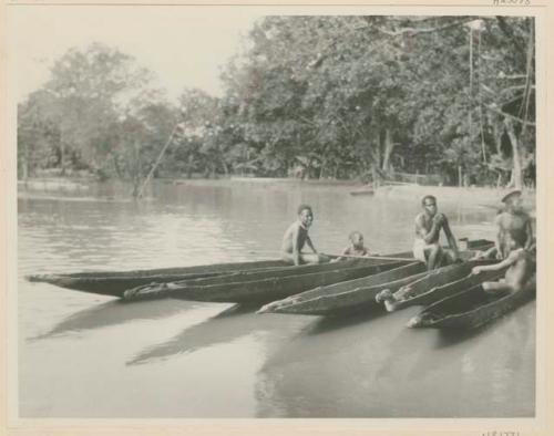 People in canoes with carved figureheads