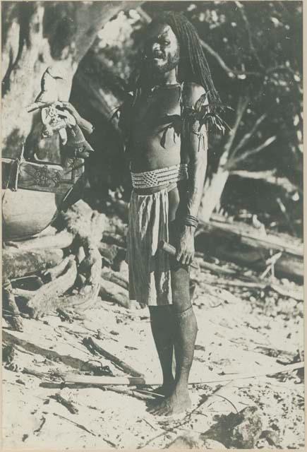 Man beside ornately carved bow of canoe