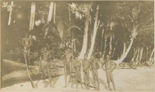 Boys on beach in front of jungle