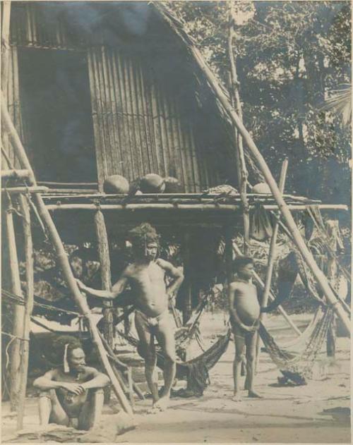 Group of men by house with hammocks