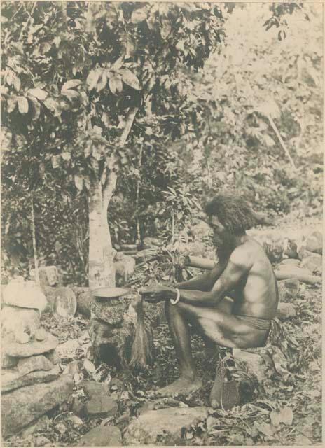 Man sitting, handling fibrous material