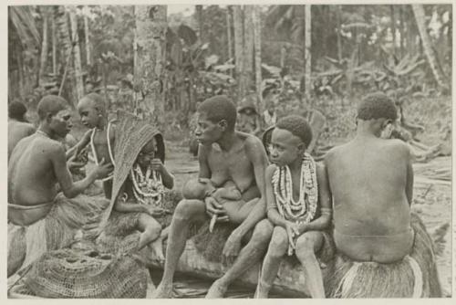 Women, nursing child, child in rain hood