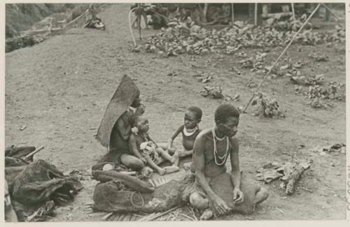 Women and children, one in rain hood