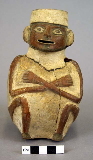 Brown and white pot in form of sitting man