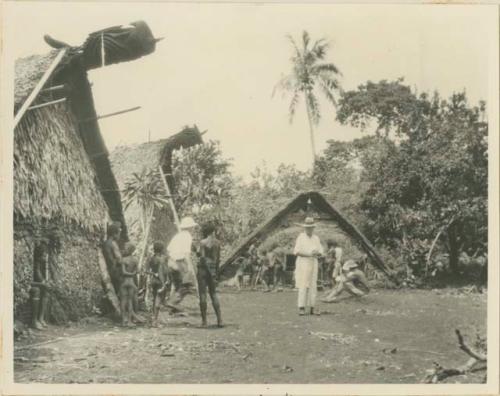 Men and boys standing in front of sacred houses