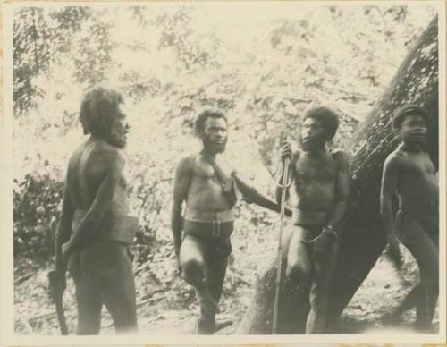 Men standing next to a tree