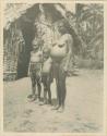 Woman with two children wearing necklaces and girdles made of shell money