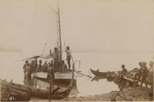 Men and boys with a boat and canoes