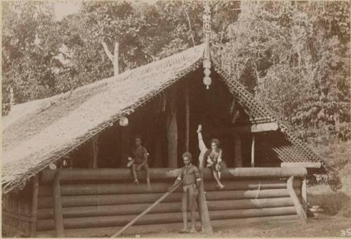 Three people in front of house