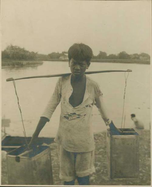 Boy with yoke and hooked buckets, lake