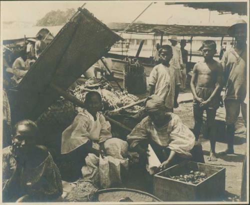 Three women working under wicker awning