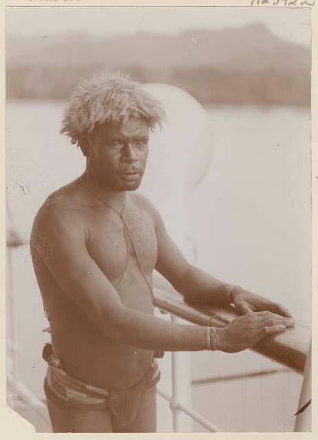 Man standing against railing of boat or pier