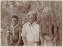 Three men in front of a large tree