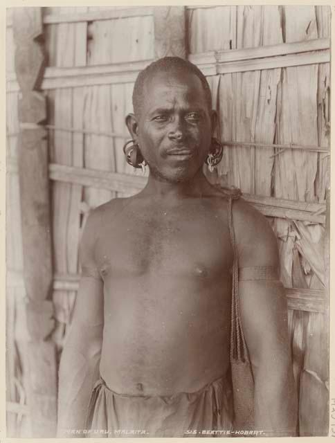 Man standing in front of thatched structure