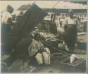 Woman with cigarette working under wicker awning