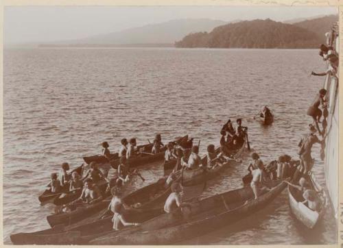 Women of Nore Four in canoes, trading with ship