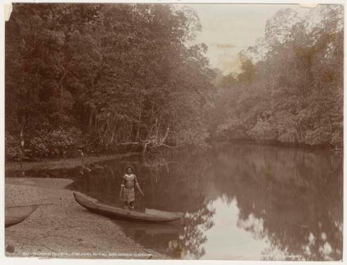 Man standing in canoe on shore of Bulalaka River