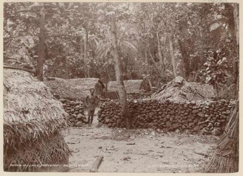 Man standing next to rock wall in the village of Matema