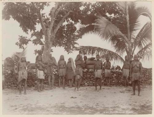 Group of women and children in front of stone wall at Matema