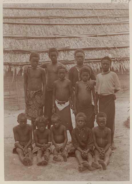 Group of boys in front of thatched structure
