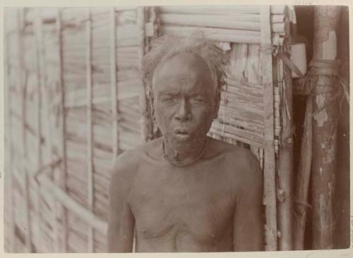 Man standing in front of thatched structure