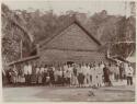 People of Minordu in front of large thatched structure