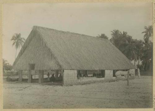 People inside large thatched structure